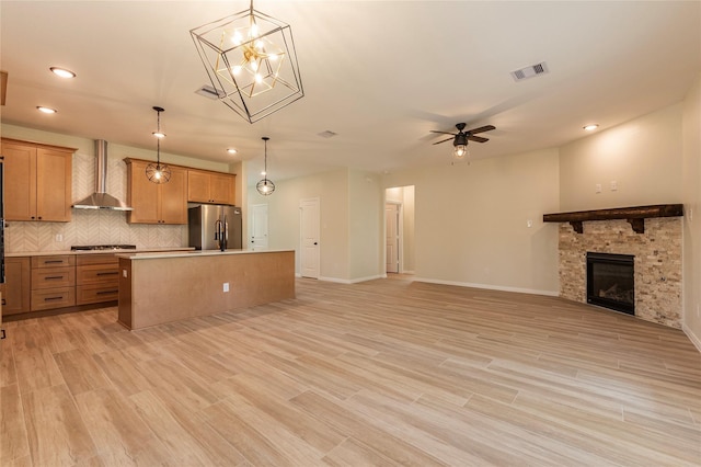 14606 W 6th St, Santa Fe, TX 77517 - kitchen featuring appliances with stainless steel finishes, wall chimney range hood, open floor plan, a kitchen island, and tasteful backsplash