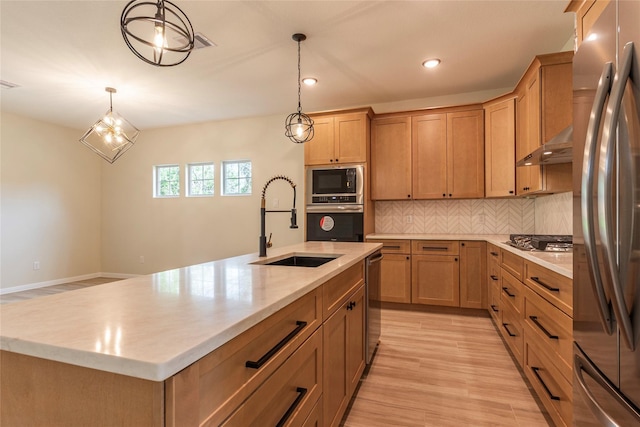 14606 W 6th St, Santa Fe, TX 77517 - kitchen with stainless steel appliances, a sink, under cabinet range hood, tasteful backsplash, and hanging light fixtures