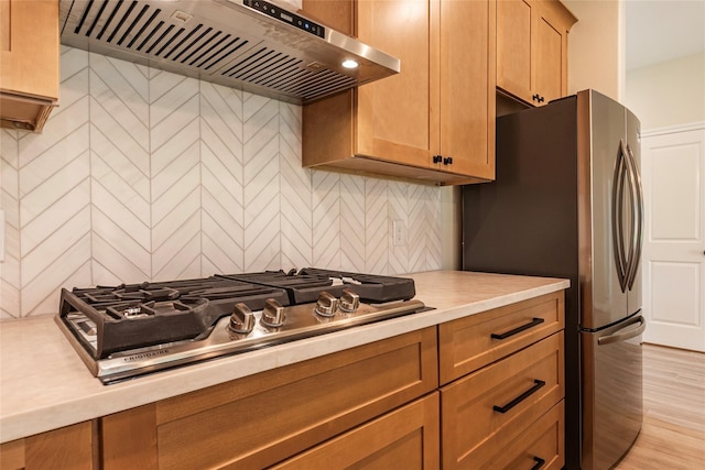 14606 W 6th St, Santa Fe, TX 77517 - kitchen with ventilation hood, stainless steel appliances, light countertops, backsplash, and light wood finished floors