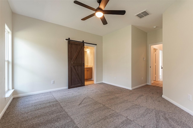 14606 W 6th St, Santa Fe, TX 77517 - unfurnished bedroom with carpet, a barn door, baseboards, and a ceiling fan