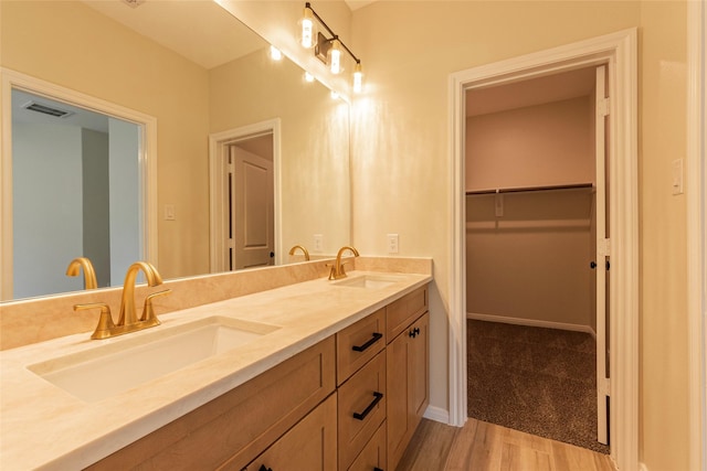 14606 W 6th St, Santa Fe, TX 77517 - bathroom with double vanity, wood finished floors, a spacious closet, and baseboards