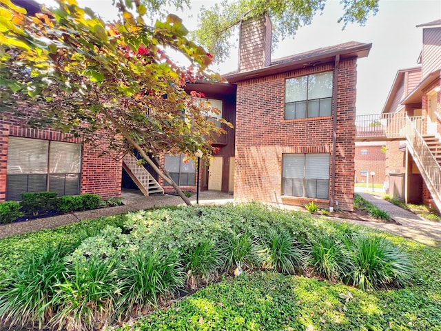 3130 Walnut Bend Ln Unit 409, Houston, TX 77042 - view of front facade with stairs, brick siding, and a chimney