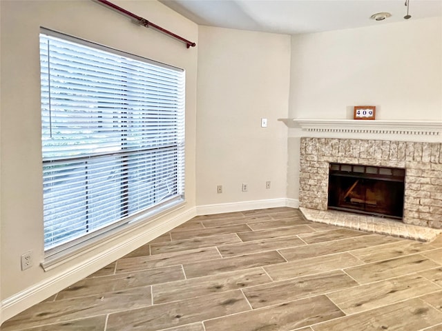 3130 Walnut Bend Ln Unit 409, Houston, TX 77042 - unfurnished living room with wood finished floors, baseboards, and a fireplace with raised hearth
