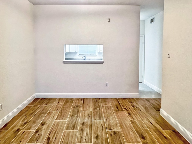 3130 Walnut Bend Ln Unit 409, Houston, TX 77042 - unfurnished room with wood finished floors, baseboards, and a sink