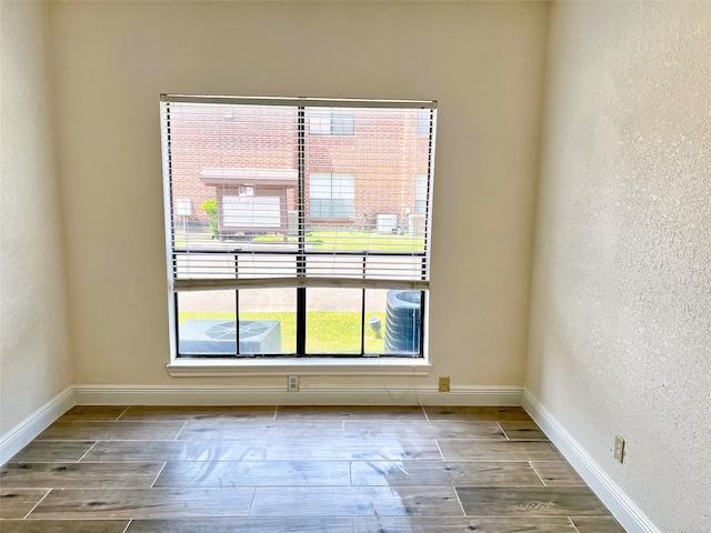 3130 Walnut Bend Ln Unit 409, Houston, TX 77042 - spare room featuring wood finished floors, a textured wall, and baseboards