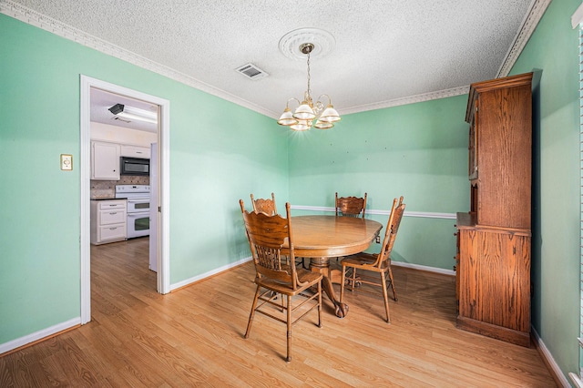 3823 Fernglade Dr, Houston, TX 77068 - dining area with ornamental molding, a chandelier, light wood-type flooring, a textured ceiling, and baseboards