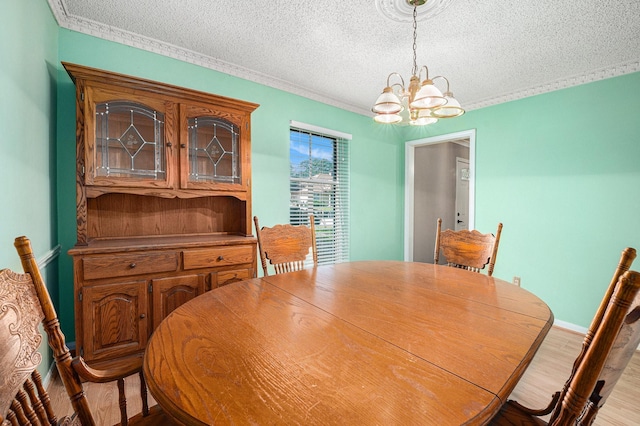 3823 Fernglade Dr, Houston, TX 77068 - dining space featuring a textured ceiling, a chandelier, wood finished floors, and crown molding
