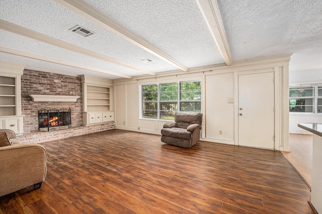 3823 Fernglade Dr, Houston, TX 77068 - living room featuring a textured ceiling, wood finished floors, a brick fireplace, beamed ceiling, and built in shelves