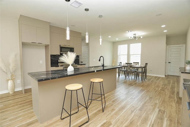 16803 Forest Trail Dr, Channelview, TX 77530 - kitchen featuring stainless steel microwave, a sink, dark countertops, light wood finished floors, and recessed lighting