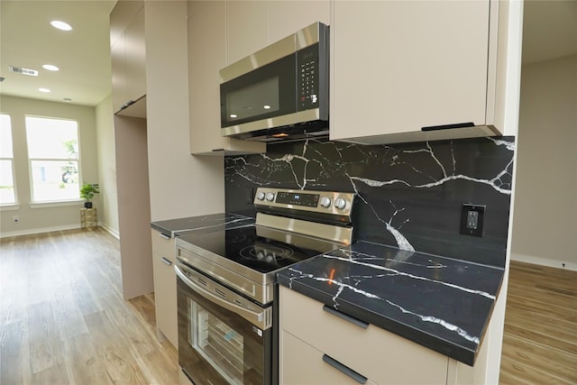 16803 Forest Trail Dr, Channelview, TX 77530 - kitchen with stainless steel appliances, light wood finished floors, tasteful backsplash, white cabinetry, and recessed lighting