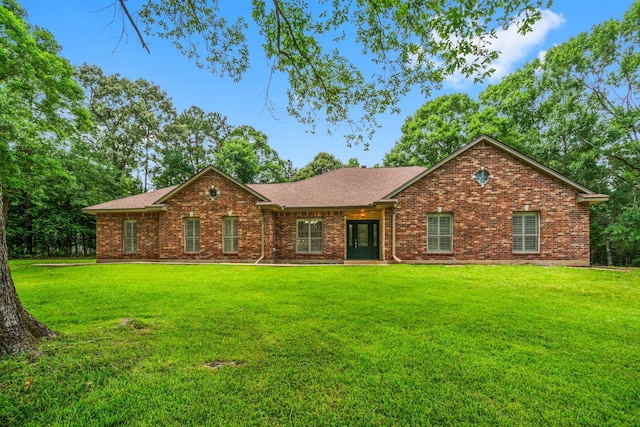 235 Hubert Ln, Livingston, TX 77351 - view of front of house with brick siding, a front yard, and roof with shingles