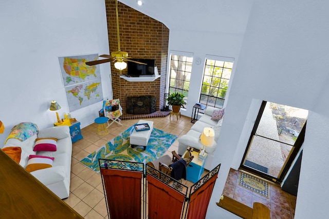 3100 75th St Unit 5, Galveston, TX 77551 - living room with light tile patterned floors, a fireplace, a ceiling fan, and vaulted ceiling