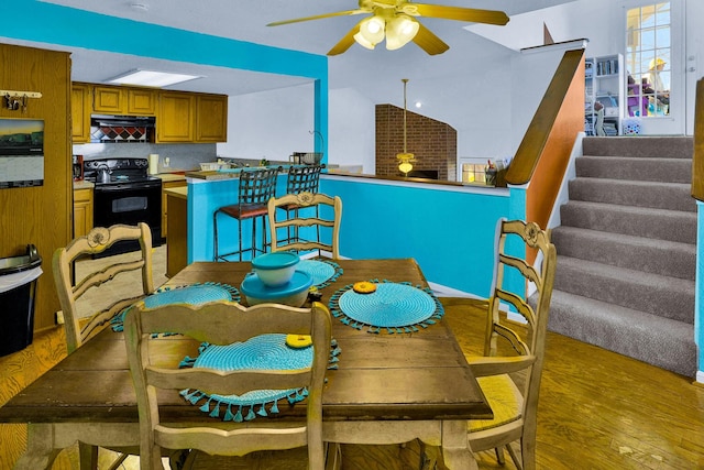 3100 75th St Unit 5, Galveston, TX 77551 - dining room featuring light wood finished floors, stairway, ceiling fan, and vaulted ceiling