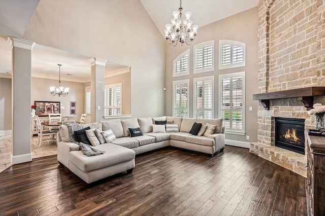 2919 Rutherford Place Ct, Katy, TX 77494 - living room with a chandelier, dark wood-type flooring, a stone fireplace, ornate columns, and high vaulted ceiling