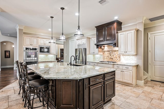 2919 Rutherford Place Ct, Katy, TX 77494 - kitchen featuring stainless steel appliances, crown molding, baseboards, a sink, and under cabinet range hood