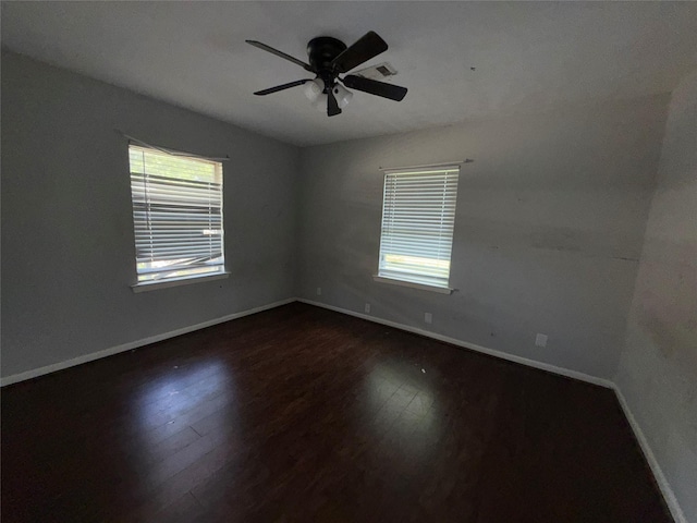 1307 Olive St, Baytown, TX 77520 - empty room featuring healthy amount of natural light, baseboards, dark wood-style flooring, and ceiling fan