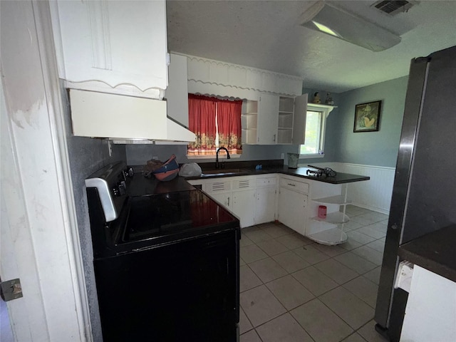 1307 Olive St, Baytown, TX 77520 - kitchen with open shelves, black electric range oven, a sink, freestanding refrigerator, and wainscoting