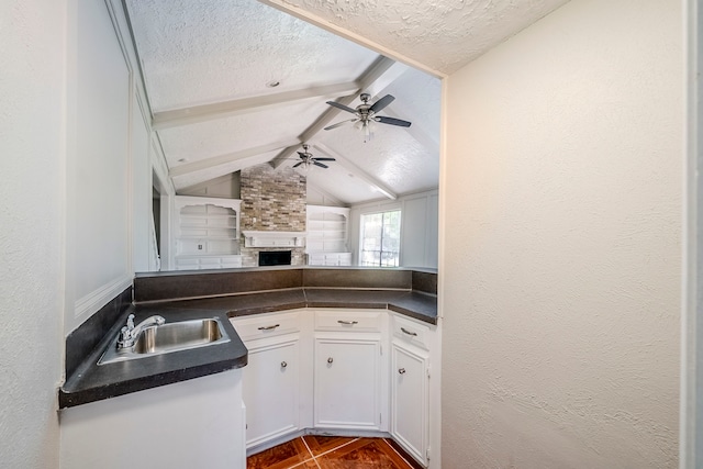 15714 Pebble Bend Dr, Houston, TX 77068 - kitchen with a sink, a textured ceiling, dark countertops, ceiling fan, and white cabinetry