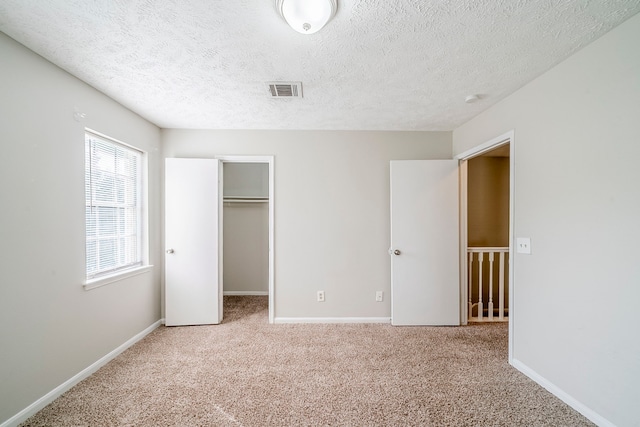 15714 Pebble Bend Dr, Houston, TX 77068 - unfurnished bedroom with carpet floors, a textured ceiling, baseboards, a walk in closet, and a closet
