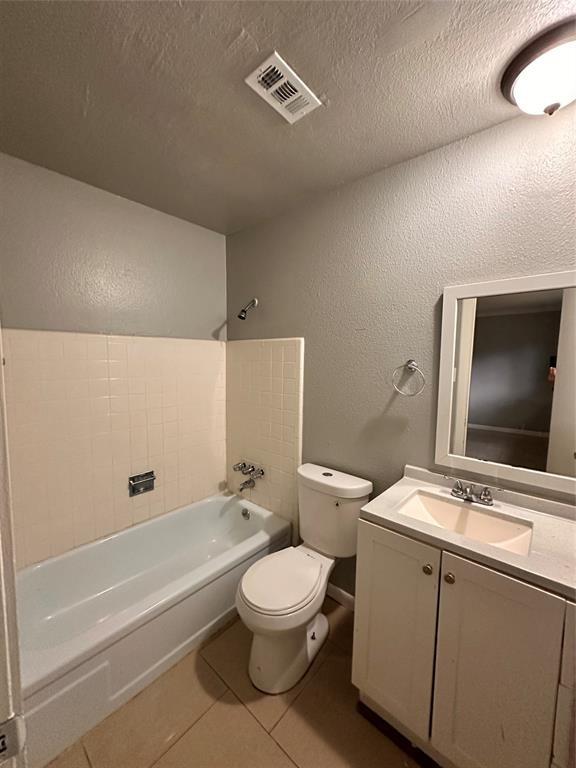 738 Beachcomber Ln, Houston, TX 77062 - full bath with toilet, tub / shower combination, vanity, a textured wall, and tile patterned flooring