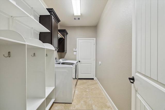 27208 Adrian Hills Ln, Spring, TX 77386 - laundry area featuring washing machine and clothes dryer, baseboards, cabinet space, and light tile patterned flooring