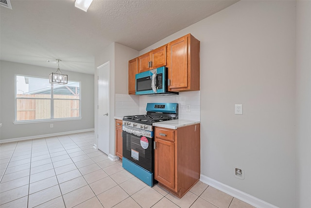2706 Star Peak Dr, Houston, TX 77088 - kitchen featuring appliances with stainless steel finishes, light countertops, backsplash, brown cabinetry, and baseboards