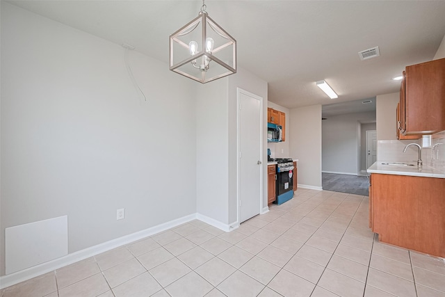 2706 Star Peak Dr, Houston, TX 77088 - kitchen with appliances with stainless steel finishes, a sink, brown cabinets, light countertops, and baseboards