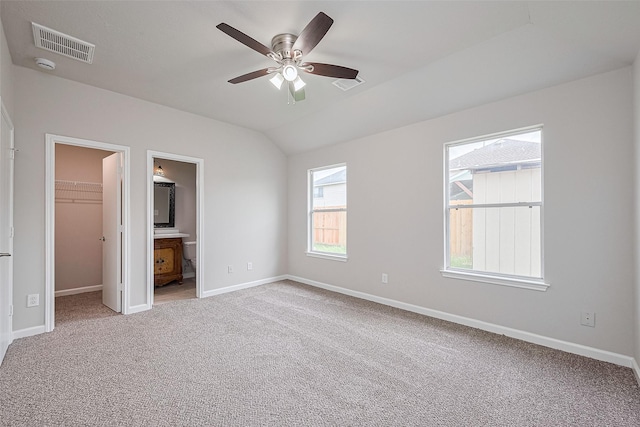 2706 Star Peak Dr, Houston, TX 77088 - unfurnished bedroom with a walk in closet, carpet flooring, baseboards, ensuite bathroom, and vaulted ceiling