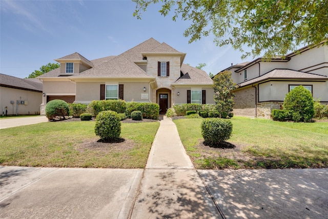 4218 Tanner Woods Ln, Sugar Land, TX 77479 - traditional home featuring a front lawn, driveway, roof with shingles, a garage, and stucco siding