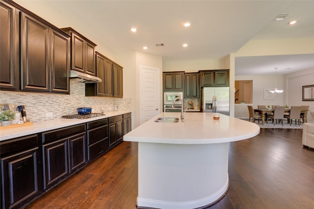 4218 Tanner Woods Ln, Sugar Land, TX 77479 - kitchen with stainless steel appliances, a sink, under cabinet range hood, light countertops, and dark wood finished floors