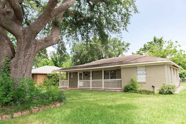 108 Chandler Dr, Baytown, TX 77521 - view of front of home with brick siding, a front lawn, and a porch