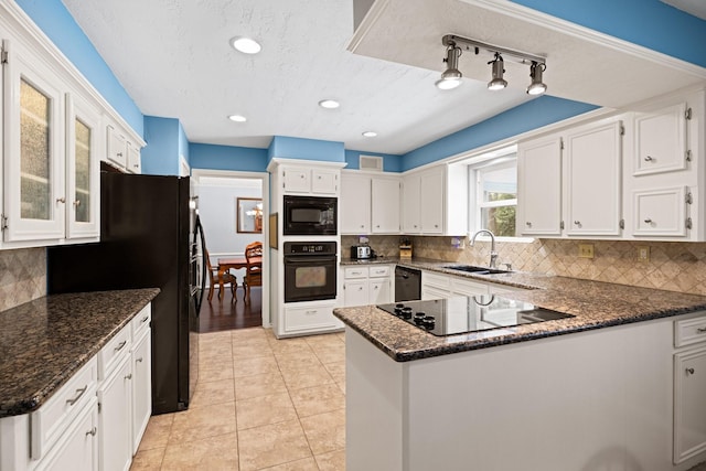 kitchen with black appliances, a sink, a peninsula, white cabinetry, and backsplash