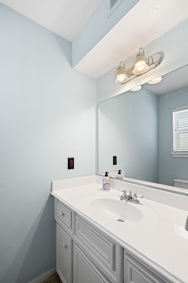 bathroom featuring vanity and toilet