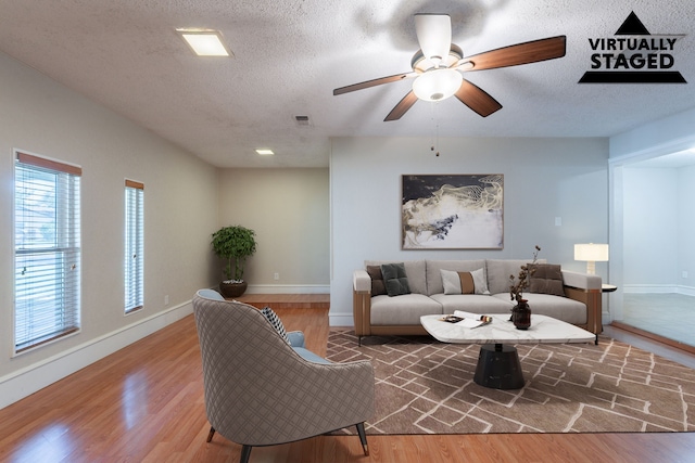 16466 Mandate Dr, Houston, TX 77049 - living room featuring wood finished floors, a textured ceiling, ceiling fan, and baseboards