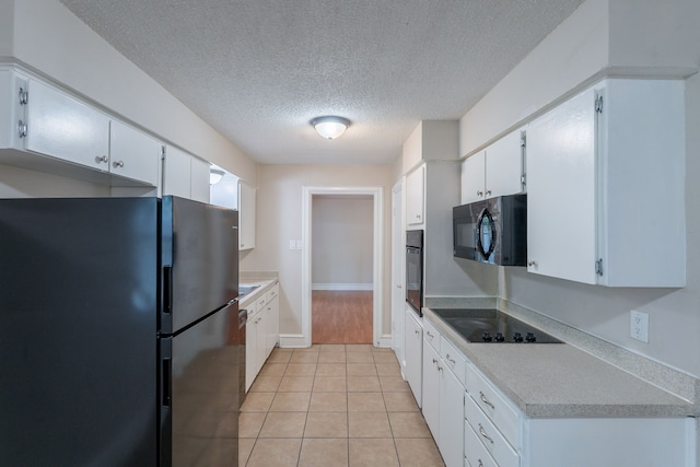 16466 Mandate Dr, Houston, TX 77049 - kitchen with black appliances, a textured ceiling, light tile patterned floors, light countertops, and white cabinetry