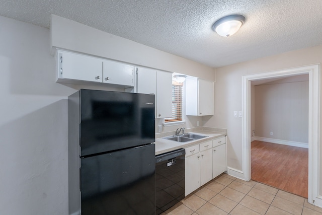 16466 Mandate Dr, Houston, TX 77049 - kitchen with black appliances, a textured ceiling, a sink, light countertops, and white cabinetry