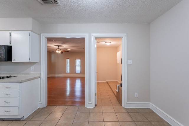 16466 Mandate Dr, Houston, TX 77049 - kitchen featuring a ceiling fan, black microwave, a textured ceiling, light tile patterned floors, and light countertops