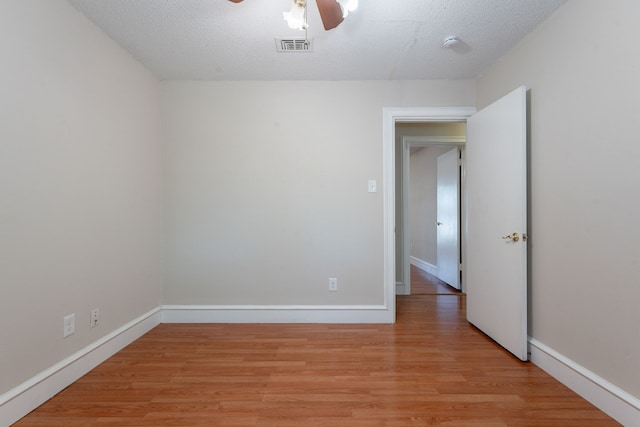 16466 Mandate Dr, Houston, TX 77049 - empty room with light wood finished floors, ceiling fan, baseboards, a smoke detector, and a textured ceiling