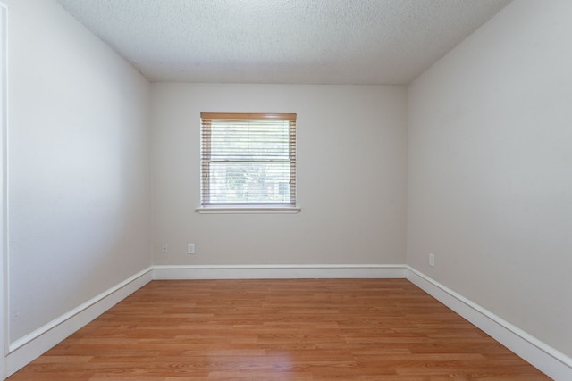 16466 Mandate Dr, Houston, TX 77049 - unfurnished room with light wood finished floors, a textured ceiling, and baseboards