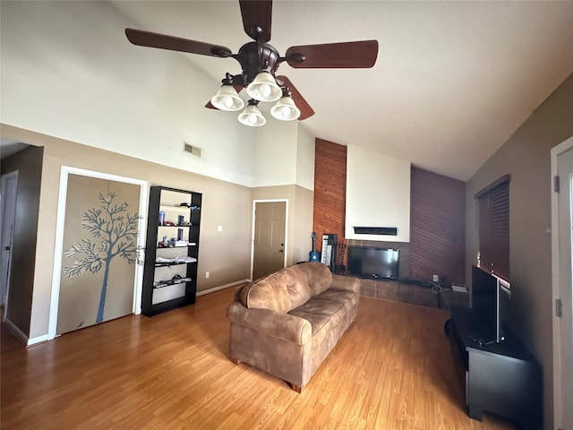 618 Hickory St, Huntsville, TX 77320 - living area with high vaulted ceiling, ceiling fan, wood finished floors, a brick fireplace, and baseboards
