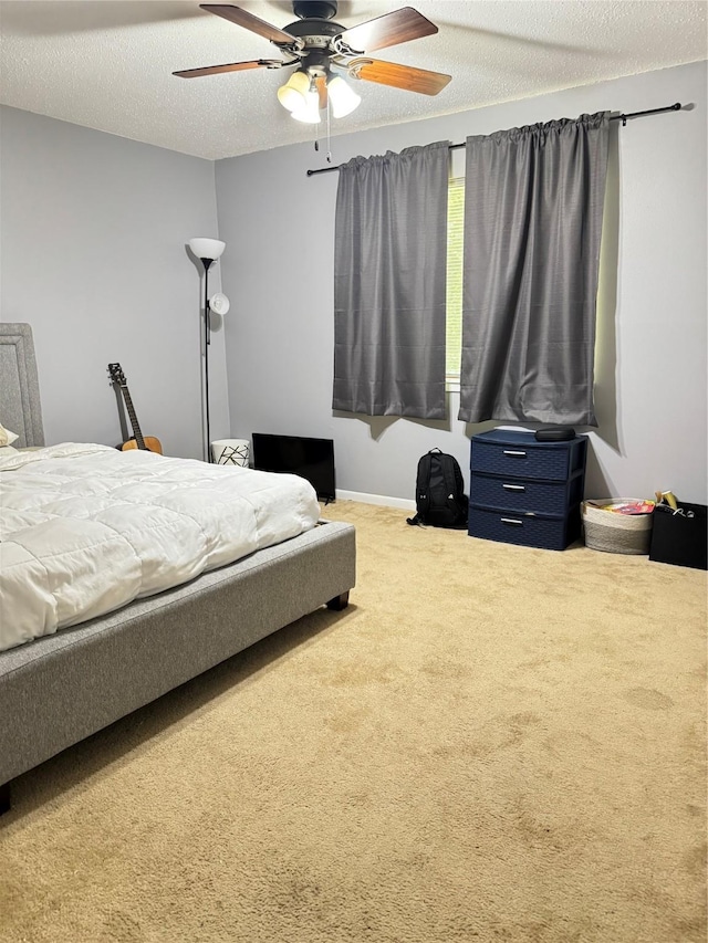 618 Hickory St, Huntsville, TX 77320 - bedroom featuring carpet floors, a textured ceiling, a ceiling fan, and baseboards