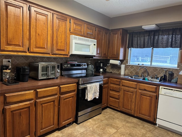 618 Hickory St, Huntsville, TX 77320 - kitchen with white appliances, dark countertops, decorative backsplash, brown cabinets, and a textured ceiling