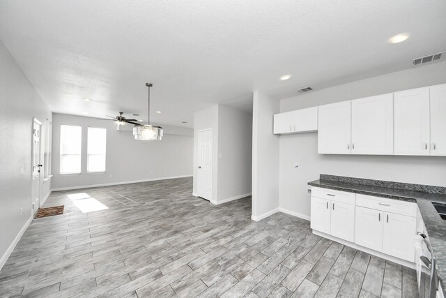 273 Rd 5134, Cleveland, TX 77327 - kitchen featuring a ceiling fan, baseboards, white cabinets, light wood-style floors, and dark countertops