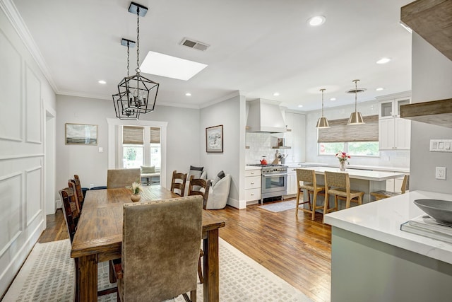 3708 Watson St, Houston, TX 77009 - dining space with a skylight, wood finished floors, recessed lighting, and crown molding
