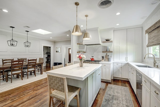 3708 Watson St, Houston, TX 77009 - kitchen with open shelves, a sink, a skylight, dark wood-type flooring, and crown molding