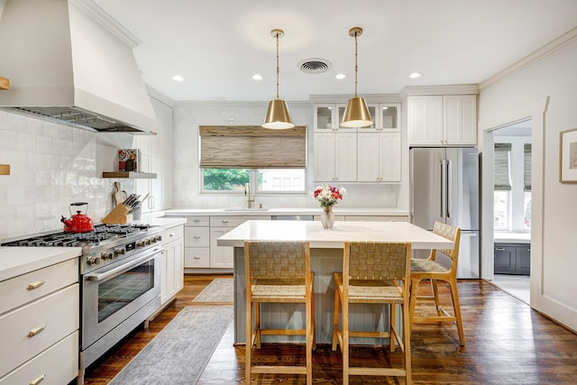 3708 Watson St, Houston, TX 77009 - kitchen with high quality appliances, custom range hood, ornamental molding, a sink, and backsplash