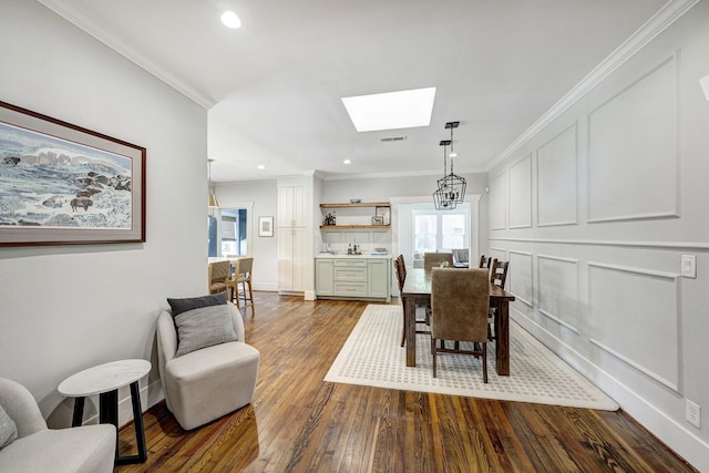 3708 Watson St, Houston, TX 77009 - dining space featuring a skylight, healthy amount of natural light, dark wood-type flooring, ornamental molding, and recessed lighting