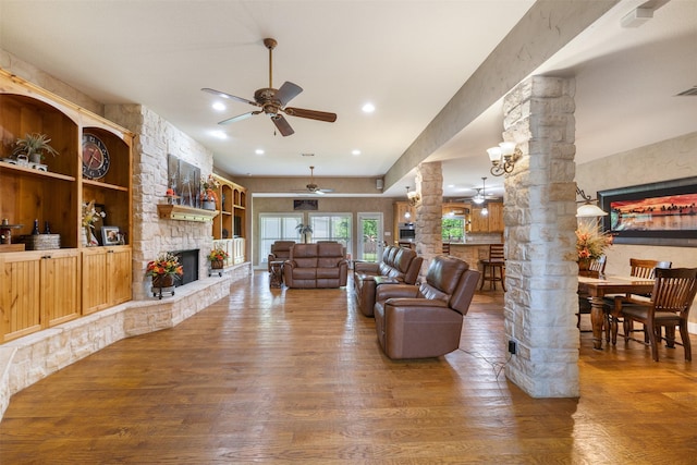 4430 Fm 546, Princeton, TX 75407 - living room with decorative columns, a ceiling fan, a fireplace, and wood finished floors