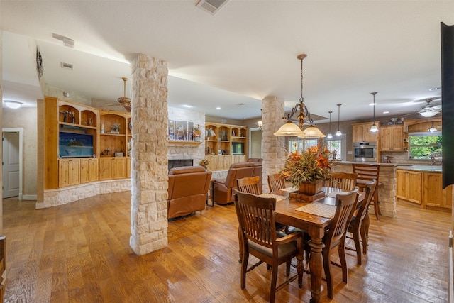 4430 Fm 546, Princeton, TX 75407 - dining space featuring light wood finished floors, a stone fireplace, and ornate columns
