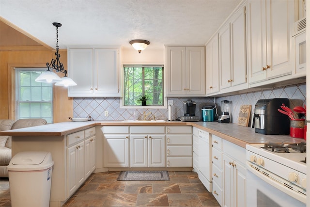 4430 Fm 546, Princeton, TX 75407 - kitchen featuring a peninsula, decorative backsplash, white appliances, white cabinets, and dark stone finish flooring